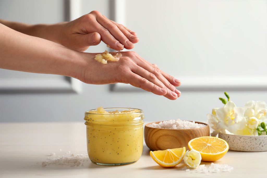 persona che fa peeling alle mani con  cera d'api e olio di argan
