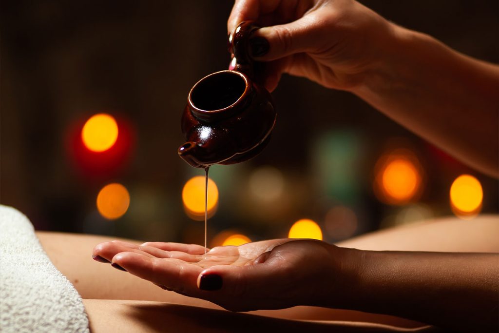 mano con olio per massaggio ayurvedico