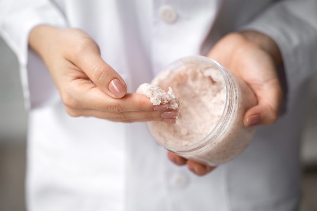 persona che prende prodotto per Peeling corpo salino esfoliante